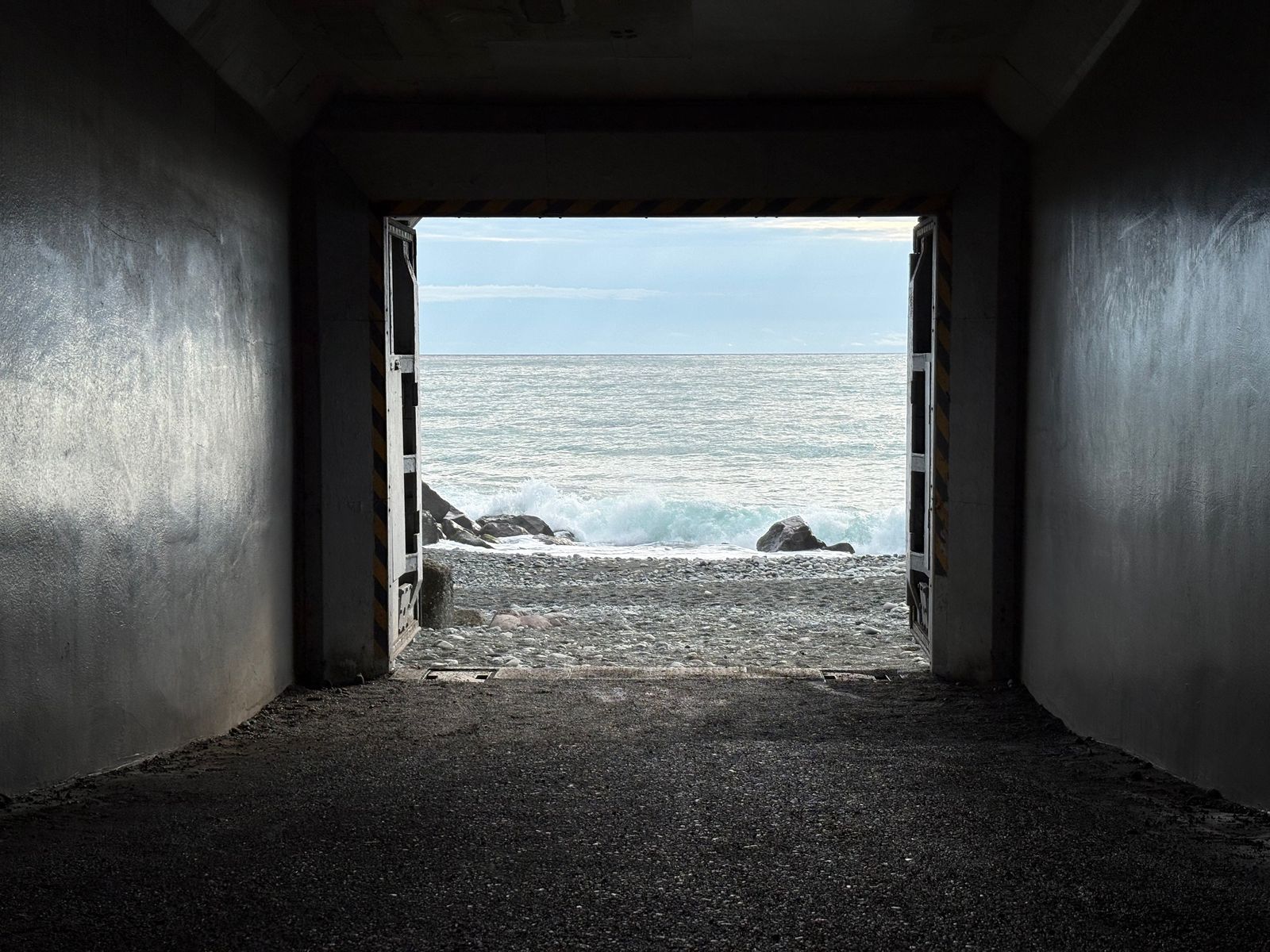 西湘バイパスの下の四角いトンネル(「海へと続くトンネル」)の先に海岸が見えている写真