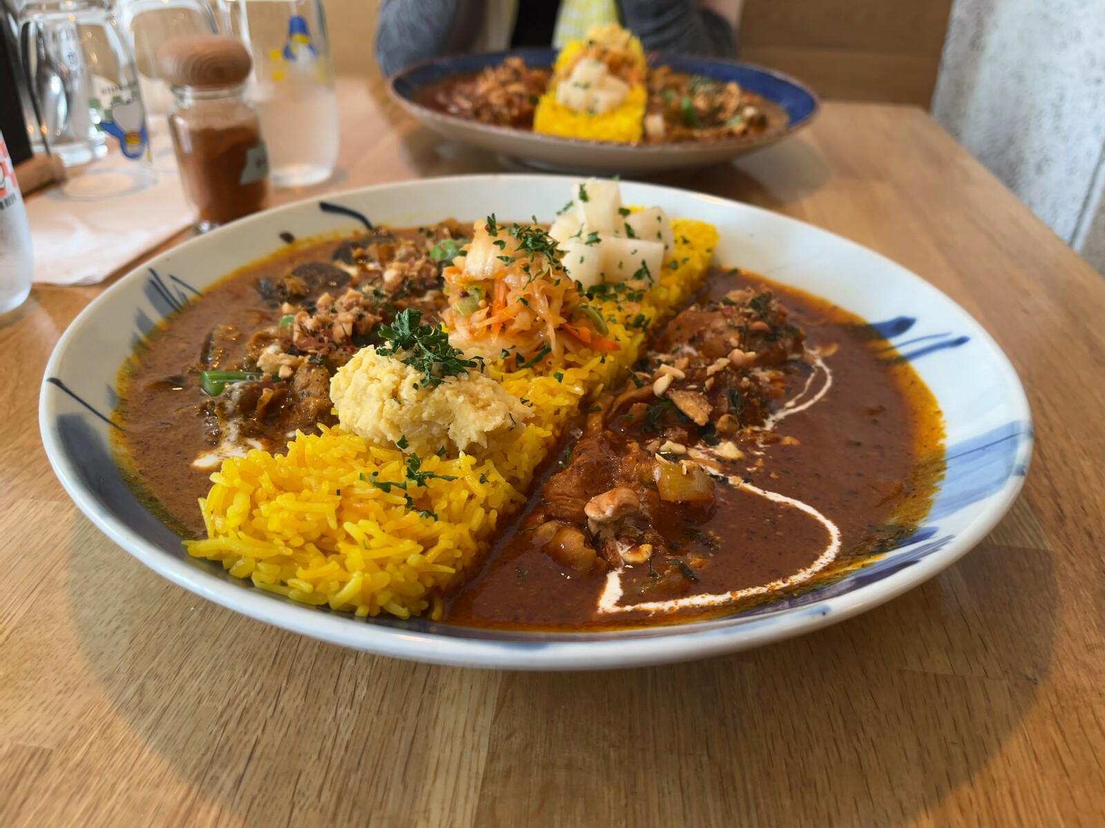 トマトチキンと夏野菜シーフード（ココナッツベース）の合いがけカレーの写真