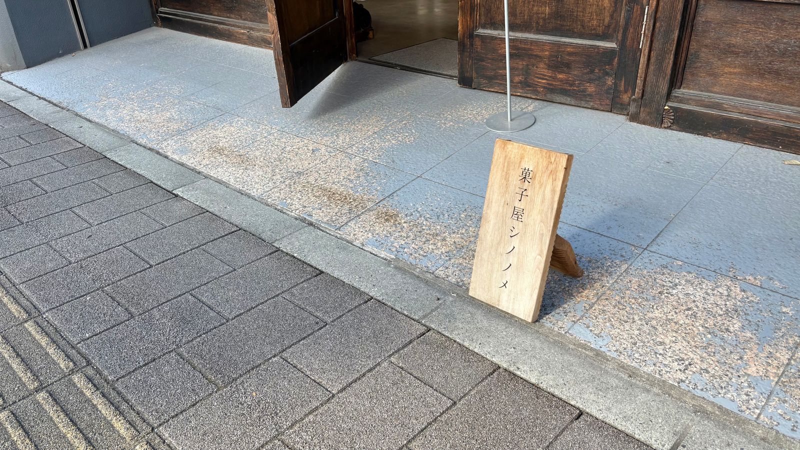 「菓子屋シノノメ」の店前の写真。道路に店名の札が立っている